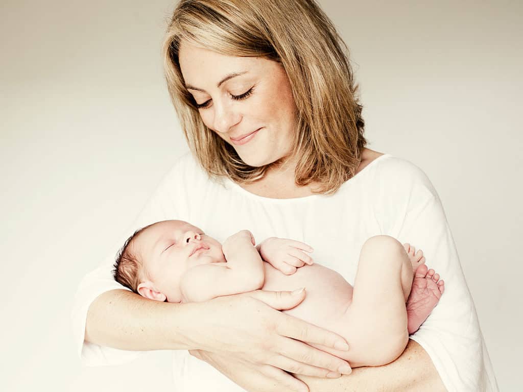 Mother smiles at her newborn baby