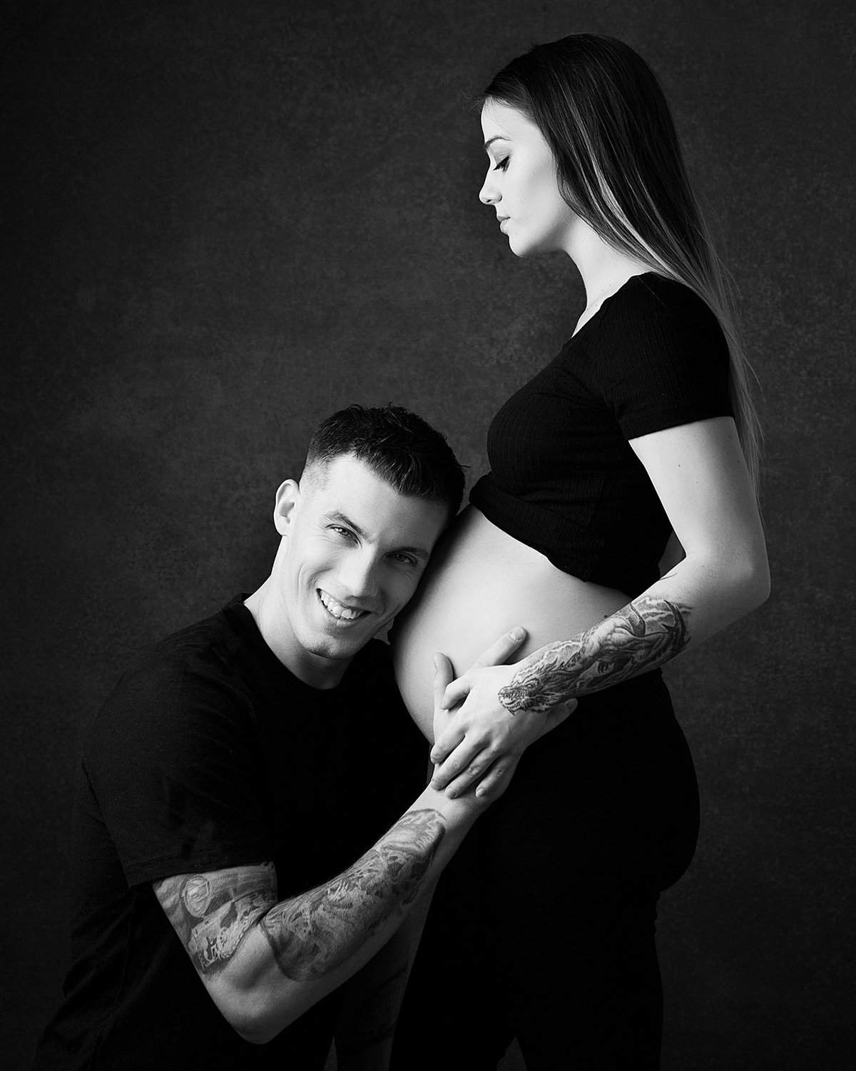 Young couple strike the pose in Maternity Photography studio in Cambridge