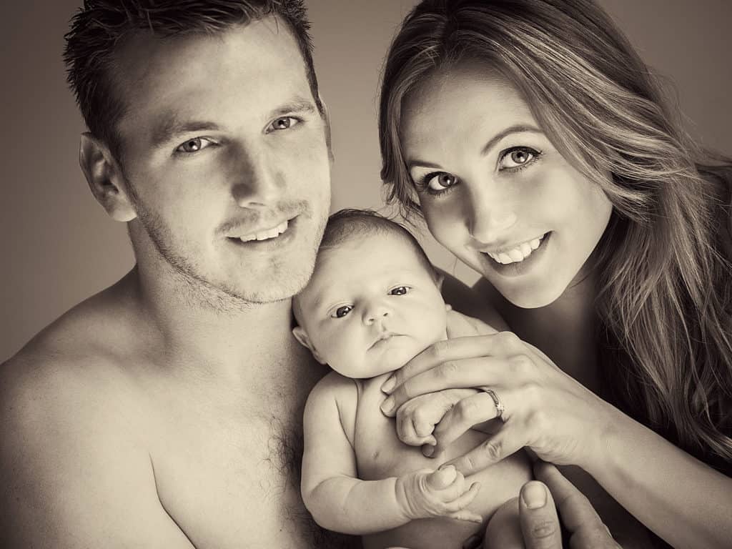 Young parents with their newborn baby having a professional photoshoot.